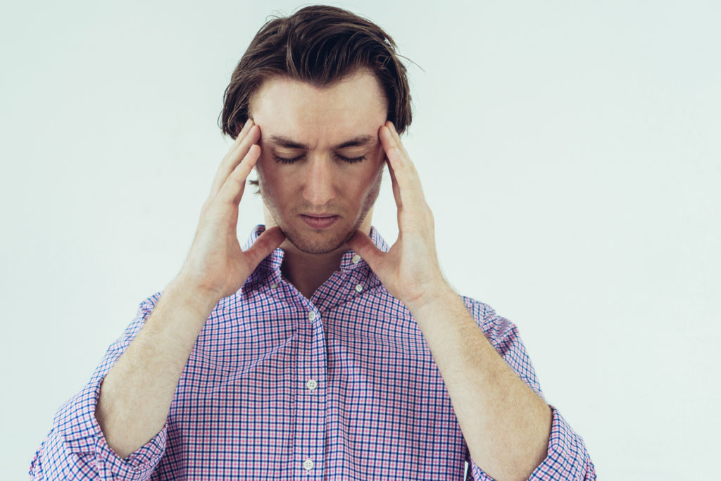 Young man holding his head in pain