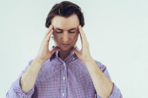 Young man holding his head in pain