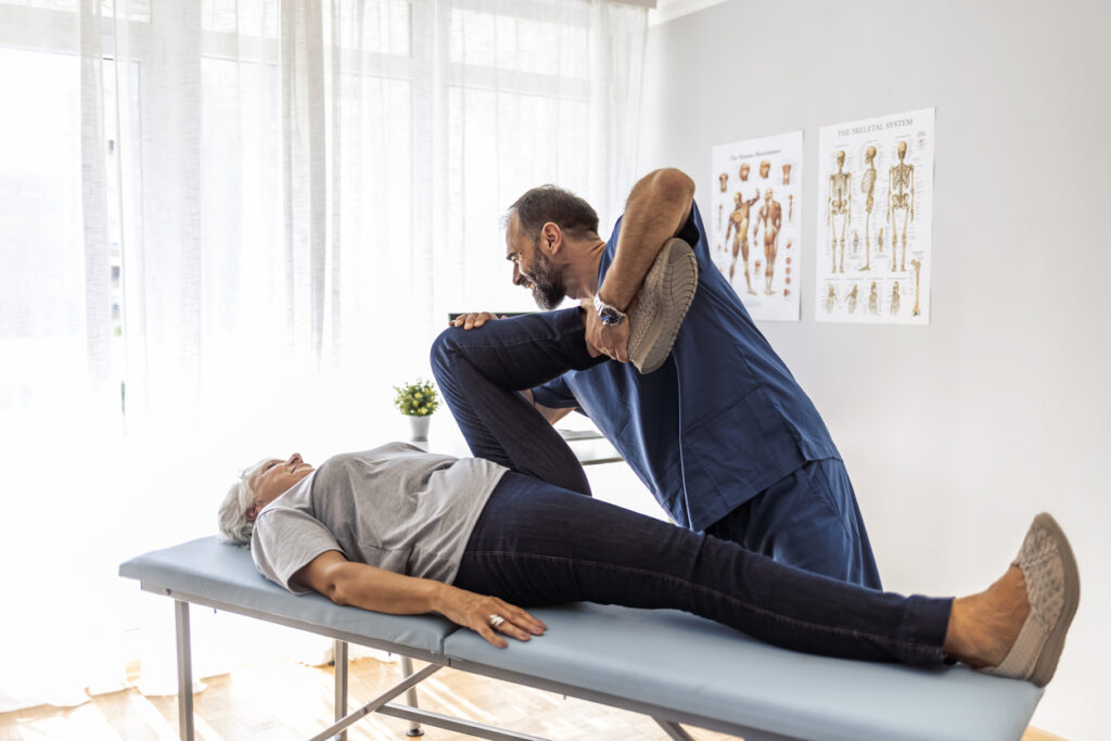 chiropractor helping patient in exercise