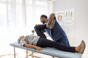 chiropractor helping patient in exercise