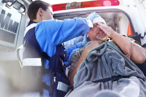 Rescue worker tending to patient at back of ambulance after car accident