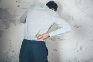 man hand in ache back on abstract background