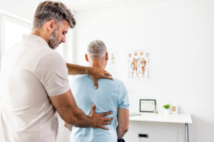 Mature man having chiropractic back adjustment