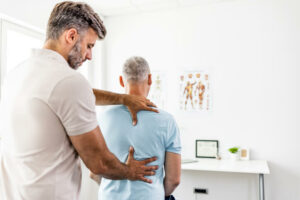 Mature man having chiropractic back adjustment
