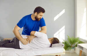 A male chiropractor is performing a chiropractic back adjustment to help a man with back problems.