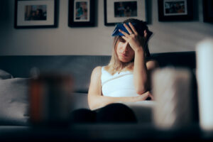 A woman using an Ice bag to alleviate migraine at home.