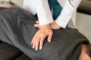 A chiropractor adjusting young patients back after auto injury.