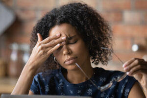 A black young lady with glasses, suffers from chronic headache.