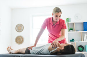 Modern rehabilitation physiotherapy clinic with professional chiropractor and client.